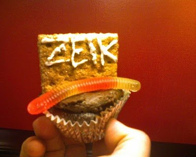 Tombstone or gravestone cupcakes with edible worms Tombstone or gravestone cupcake in case with an edible worm candy sweet