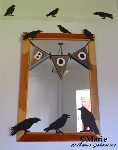 Decorated mirror with boo banner and black bird cut out decorations