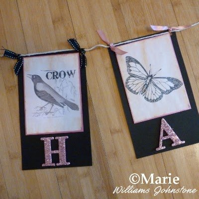 Section of a paper banner bunting with crow and butterfly designs and ribbon decoration