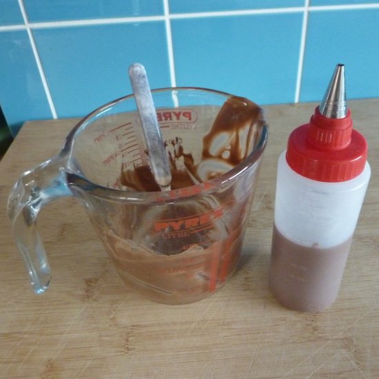 Melted chocolate for icing and a decorating bottle Kuhn Rikon decorating icing bottle and melted chocolate in a glass jug