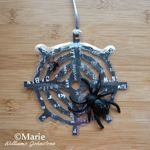 Laminated black web design with plastic spider and fly decorations