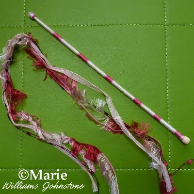 Fancy pink ribbons and a stick covered in yarn