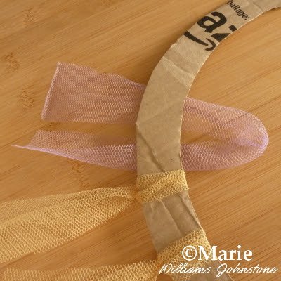 Tulle netting strips starting to tie around a cardboard base