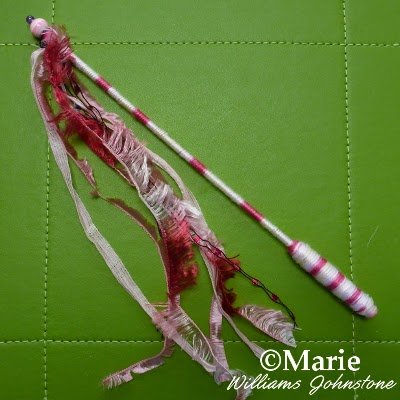 Pink and cream wand with ribbons and beads attached