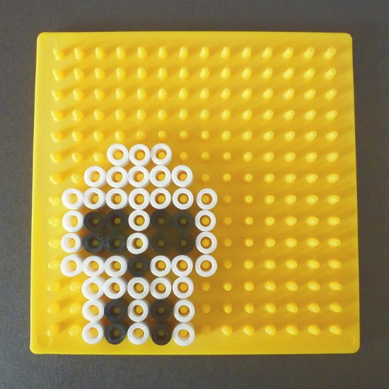 black and white simple easy small skull pattern made with beads on a fused pegboard