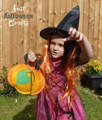 Girl dressed in costume as a Witch with a small pumpkin shaped bag
