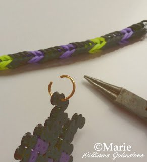 Using an open jump ring to attach a charm to a rubber band bracelet