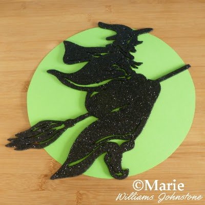 $1 store black glitter witch on green paper circle backing