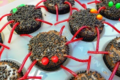 Chocolate cupcakes made to look like creepy spiders Spider decorated cakes with red legs and candy for beady eyes