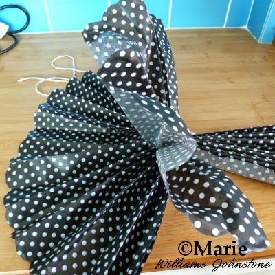 Pulling the folded paper up and separating the individual sheets