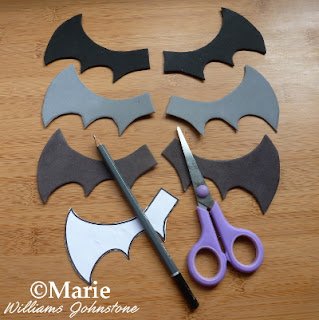 Black and gray wings cut out with scissors, pencil and template