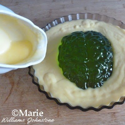 Glass dish with green lime jello middle and thick custard poured around it