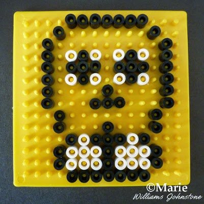 Black and white melty beads making pattern on a yellow board