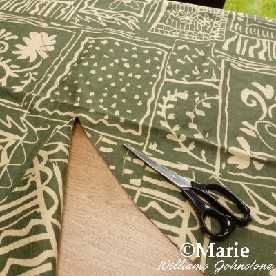 Cutting through the green patterned fabric